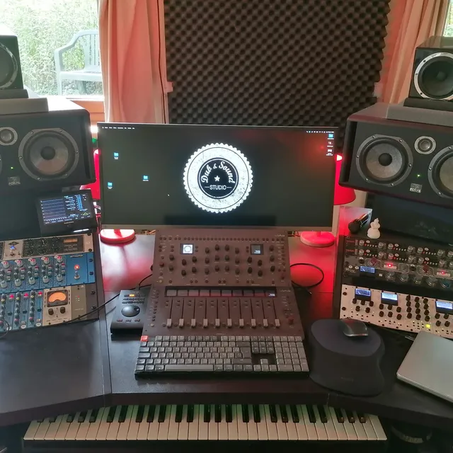 Régie d'écoute avec deux paires d'enceintes de monitoring, console analogique, sommateur et périphériques de traitement, clavier maître au premier plan